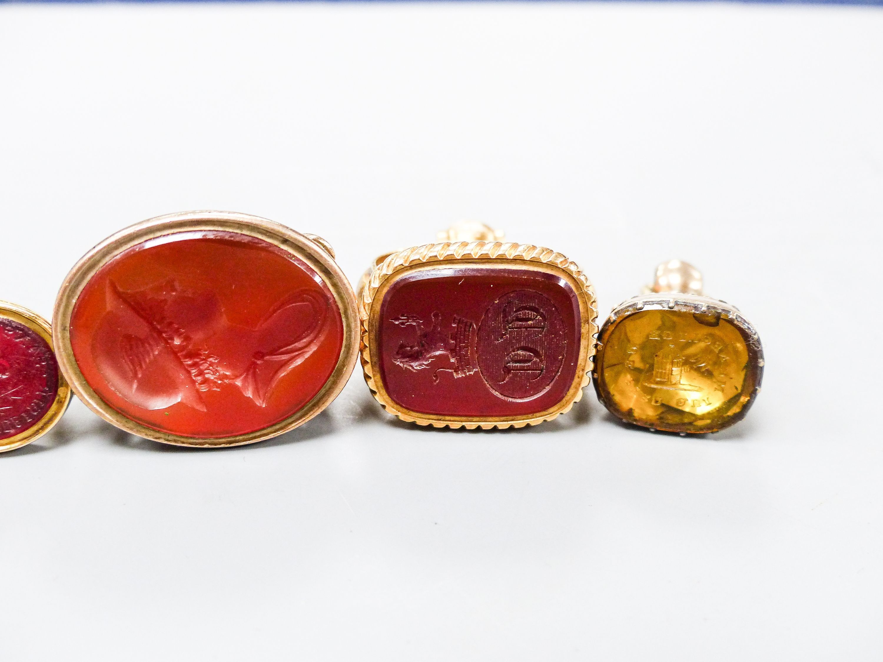 A collection of six 19th century and late assorted yellow metal overlaid and chalcedony set fob seal including one 9ct gold, largest 33mm.